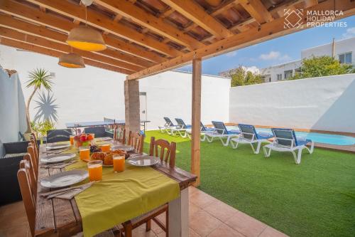 a patio with a table and chairs and a pool at Villa Fonte in Port de Pollensa