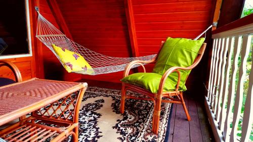 un porche con 2 sillas y una hamaca en Põlluotsa Guest House, 