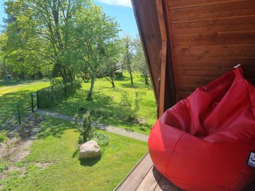 una silla roja sentada en el porche de una casa en Põlluotsa Guest House, 