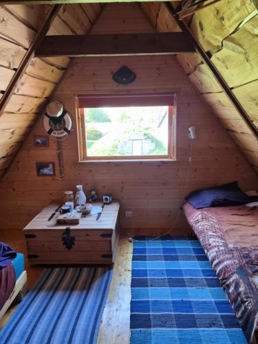 Habitación con cama y ventana en una cabaña en Põlluotsa Guest House, 