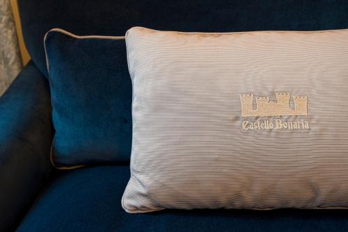 a pillow sitting on top of a blue couch at Castello Bonaria Wine & Spa Resort in Campiglia Marittima
