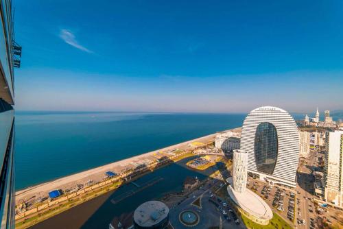 eine Luftansicht auf eine Stadt und das Meer in der Unterkunft Elegance Sea View Aparthotel In Orbi City Batumi in Batumi