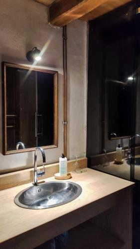 une salle de bain avec un lavabo et un miroir dans l'établissement Le Refuge du Pigeonnier, à Beynac-et-Cazenac