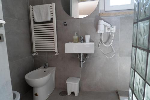 La salle de bains est pourvue de toilettes blanches et d'un lavabo. dans l'établissement Hotel VM, à Rome