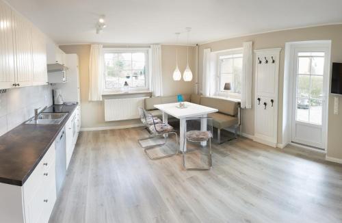 a kitchen with a table and chairs in a room at Ferienwohnung Seegras - mit Spielscheune, direkt am Wittensee in Bünsdorf