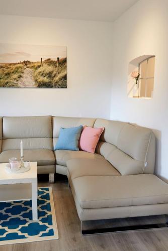 a living room with a couch and a table at Ferienwohnung Seegras - mit Spielscheune, direkt am Wittensee in Bünsdorf