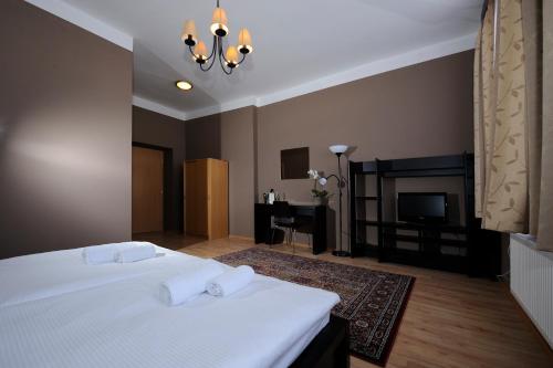 a bedroom with a white bed and a fireplace at Hotel Zlatá Štika in Pardubice