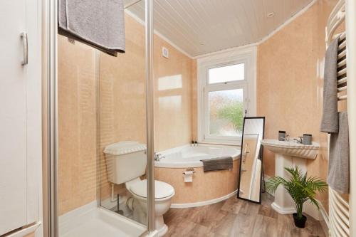 a bathroom with a toilet and a tub and a sink at Spacious 3-Bedroom House With Garden and Parking in Stockton-on-Tees