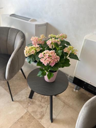 a vase of pink flowers sitting on a table at Hotel Del Ponte in Târgovişte