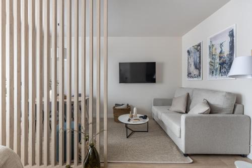 a living room with a couch and a tv at Líbere Madrid Chamberí in Madrid