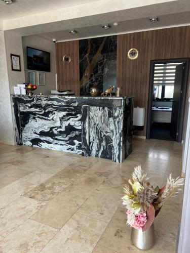 a marble counter in a room with a vase of flowers at Hotel Del Ponte in Târgovişte