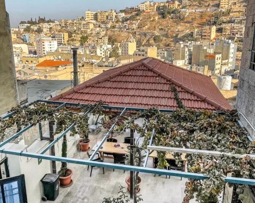 une vue sur un bâtiment avec des plantes sur le toit dans l'établissement Villa Mira Guesthouse - Downtown Central Amman - AL DIYRIH, à Amman
