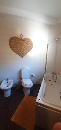 ein Badezimmer mit einem WC und einem Herz an der Wand in der Unterkunft Coimbra's Black & Gold in Coimbra
