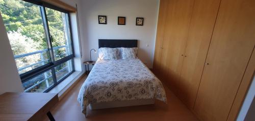 ein Schlafzimmer mit einem Bett und einem großen Fenster in der Unterkunft Coimbra's Black & Gold in Coimbra
