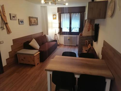 a living room with a couch and a table and chairs at Casa Flippola - Trilocale Santa Caterina Centro Paese in Santa Caterina Valfurva
