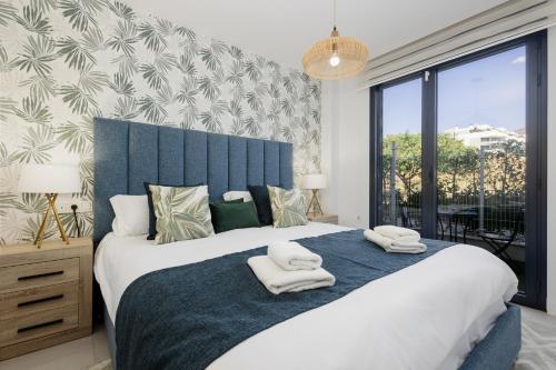 - une chambre avec un grand lit et des serviettes dans l'établissement Magnificent apartment, close to the beach, in Estepona, à Estepona