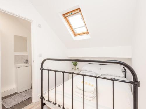 um quarto com uma cama de metal e uma clarabóia em Pass the Keys The Couples Nest close to Leeds city centre em Leeds