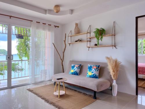 un soggiorno con divano e finestra di At The Beach Apartments a Panwa Beach