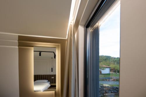 una camera da letto con finestra, letto e specchio di Hotel IN a Žepče