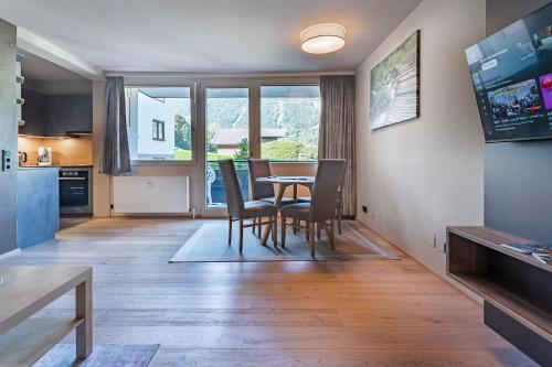 a kitchen and dining room with a table and chairs at Ski Dome Apartments-Apartment VIVA & Heaven Holiday Chalet in Kaprun