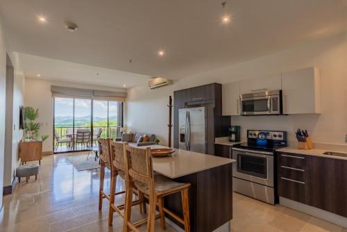 een keuken met een tafel en stoelen in een kamer bij Roble Sabana 404 Luxury Apartment Adults Only - Reserva Conchal in Playa Conchal