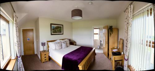 um quarto com uma cama com um cobertor roxo em Mourne Country House Bed and Breakfast em Kilkeel