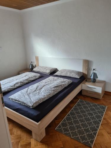 a bedroom with two beds and a rug at FeWo Liam in Alsfeld