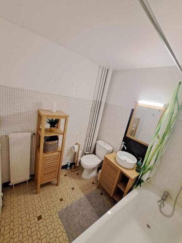 y baño con aseo, lavabo y bañera. en charmant-appartement-centre-ville Reims, en Reims