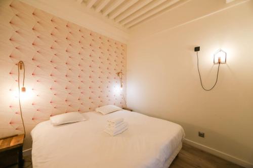 Un dormitorio con una cama blanca con toallas. en 55 m2 Apart with big terrace in Annecy downtown en Annecy