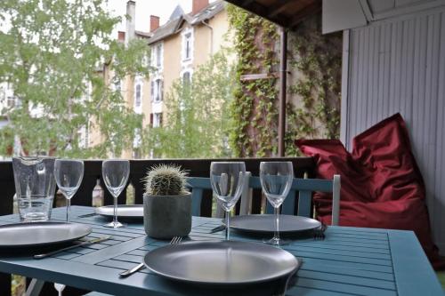 una mesa azul con platos y vasos. en 55 m2 Apart with big terrace in Annecy downtown en Annecy