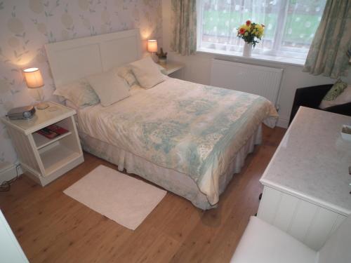a small bedroom with a bed and a window at Padog B&B in Llanrwst