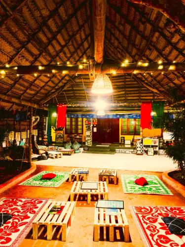 a large room with wooden tables and a large ceiling at Jambavan Arts Sanctuary in Varkala