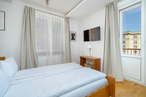 um quarto com uma cama e uma grande janela em Beautiful Apartment Aleje Marcinkowskiego with Balcony by Renters em Poznań