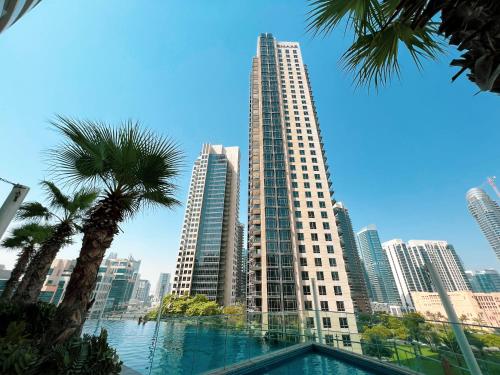 a tall building with a pool in front of a city at Magnificent - Damac Distinction Downtown in Dubai