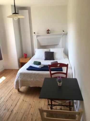 une chambre avec un lit avec deux chaises et une table dans l'établissement L'Atelier - A Quaint Retreat, à Beynac-et-Cazenac