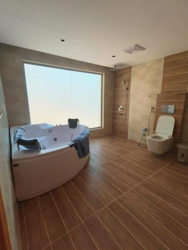 歐拉的住宿－كوخ ساره الريفي，带浴缸和卫生间的大型浴室