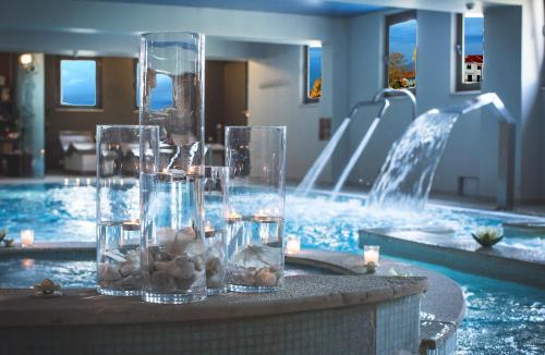 a pool with a fountain with candles and glass vases at Portaria Hotel in Portariá