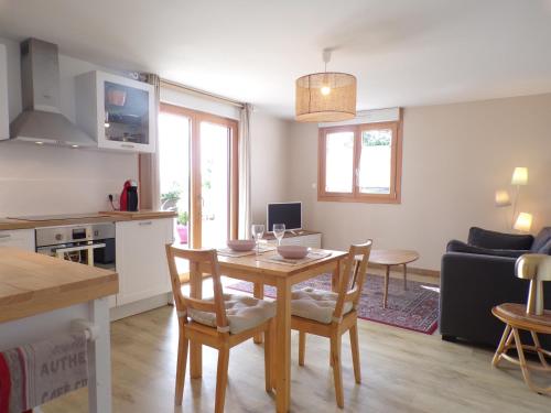 une cuisine et un salon avec une table et des chaises dans l'établissement Les clés du Vallion, T2 confort, bord de plage et paysages, à Saint-Jouan-des-Guérets