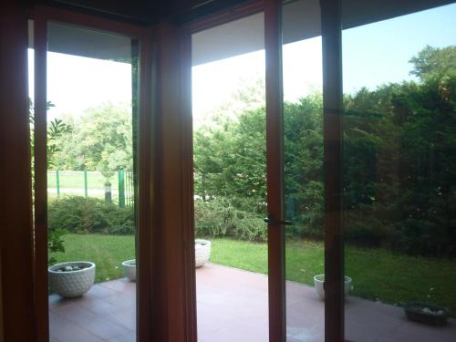an open sliding glass door with a view of a yard at Aquincum Dunaparti Apartman in Budapest