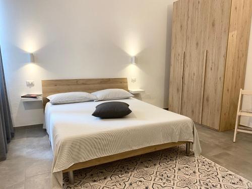 a bedroom with a bed with a black pillow on it at Alloggio 1 / Casa Marley Porto Pollo in Barrabisa