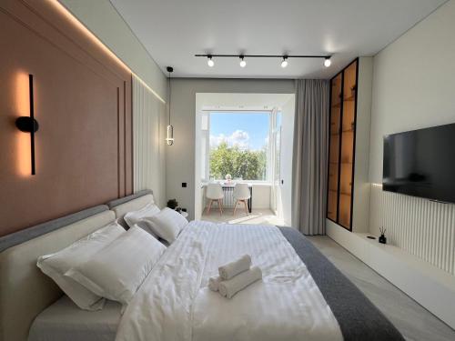 una camera da letto con un letto con due asciugamani bianchi di LUX Апартаменты SMART #7 a Pavlodar