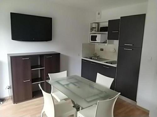 a kitchen with a table and chairs and a television at studio montagne in Les Orres