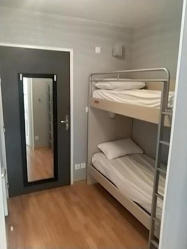 Cette petite chambre comprend des lits superposés et un miroir. dans l'établissement studio montagne, aux Orres