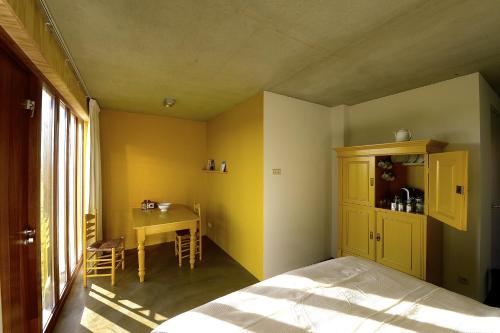 a bedroom with a bed and a desk and a table at De Kemp B&B & Studio's in Vortum-Mullem