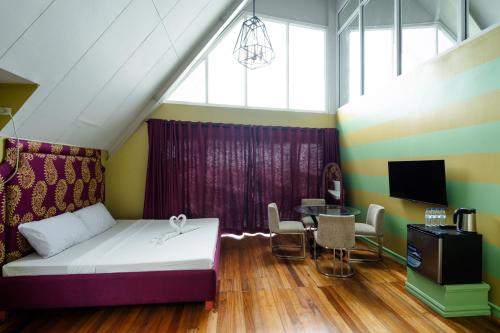 uma sala de estar com uma cama e uma mesa em Jacobs Hill Tagaytay em Tagaytay