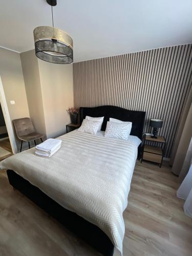 a bedroom with a large bed with white sheets at Apartament Centrum II in Lidzbark Warmiński