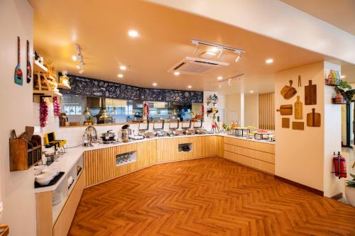 a large kitchen with wooden flooring and a large room at Bloom Hub - ORR Marathahalli in Bengaluru