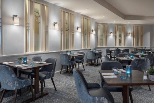 a restaurant with tables and chairs in a room at Delta Hotels by Marriott Peterborough in Peterborough