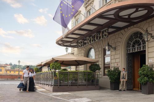 un gruppo di persone in piedi fuori da un edificio di The St. Regis Florence a Firenze