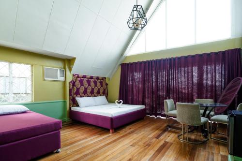 a room with a bed and a table and chairs at Jacobs Hill Tagaytay in Tagaytay